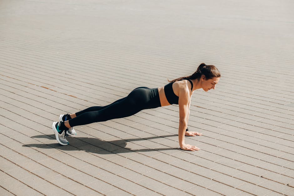 Woman doing push-ups outdoors in activewear, promoting fitness and healthy lifestyle.